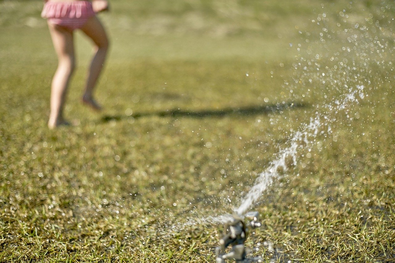 Kids running through the sprinklers